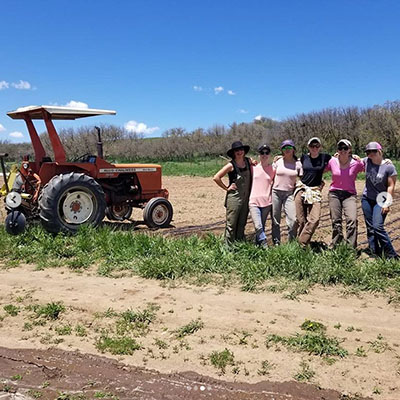 farmers in training posing near tractor